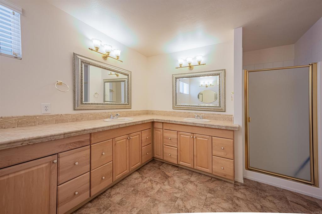 4650 Dulin Road, Unit 119 Fallbrook, CA 92003 - Photo 32 of 49 a bathroom with double vanity sink a two mirror a window and a bathtub