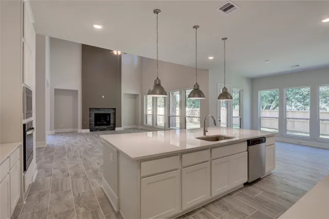 en empty room with windows and chandelier