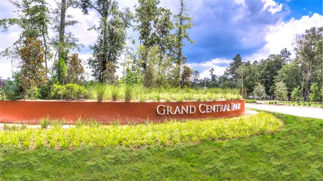 a view of a white house with a big yard and large trees
