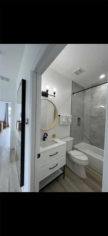 a bathroom with a sink a toilet a mirror and shower