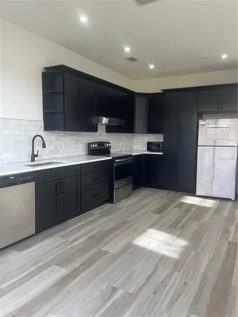 a kitchen with stainless steel appliances granite countertop a sink a stove and cabinets
