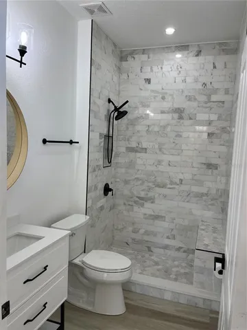 a bathroom with a toilet and a shower