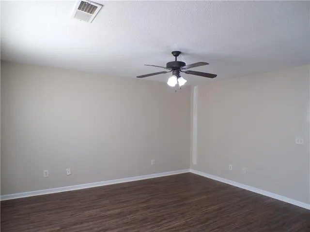 a view of a room with wooden floor and fan