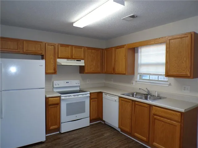 a kitchen with a sink cabinets stainless steel appliances and a window