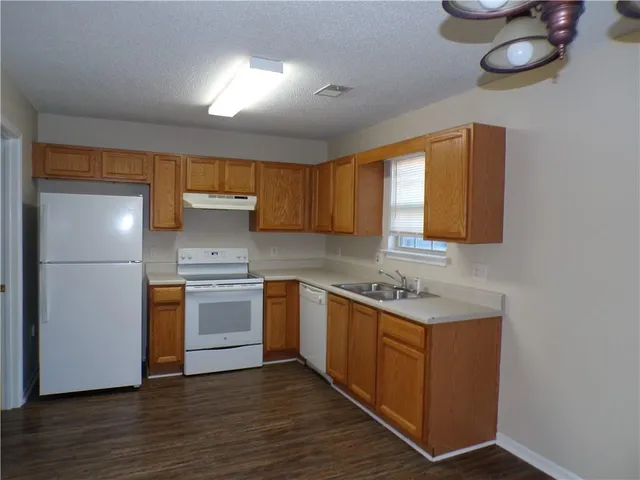 a kitchen with stainless steel appliances granite countertop a sink and a stove top oven