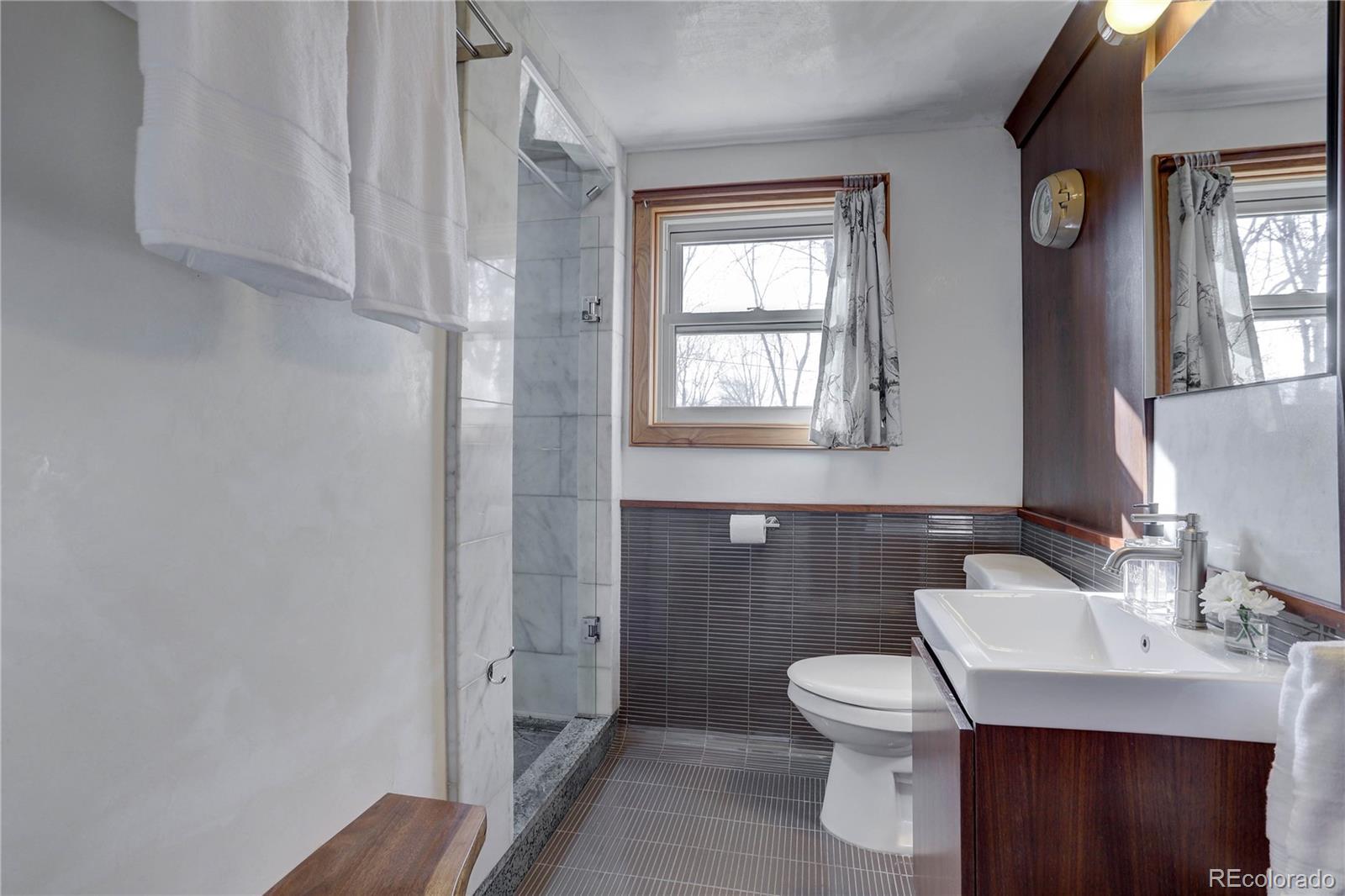 933 Cherryvale Road Boulder, CO 80303 - Photo 18 of 32 a bathroom with a toilet a sink and mirror