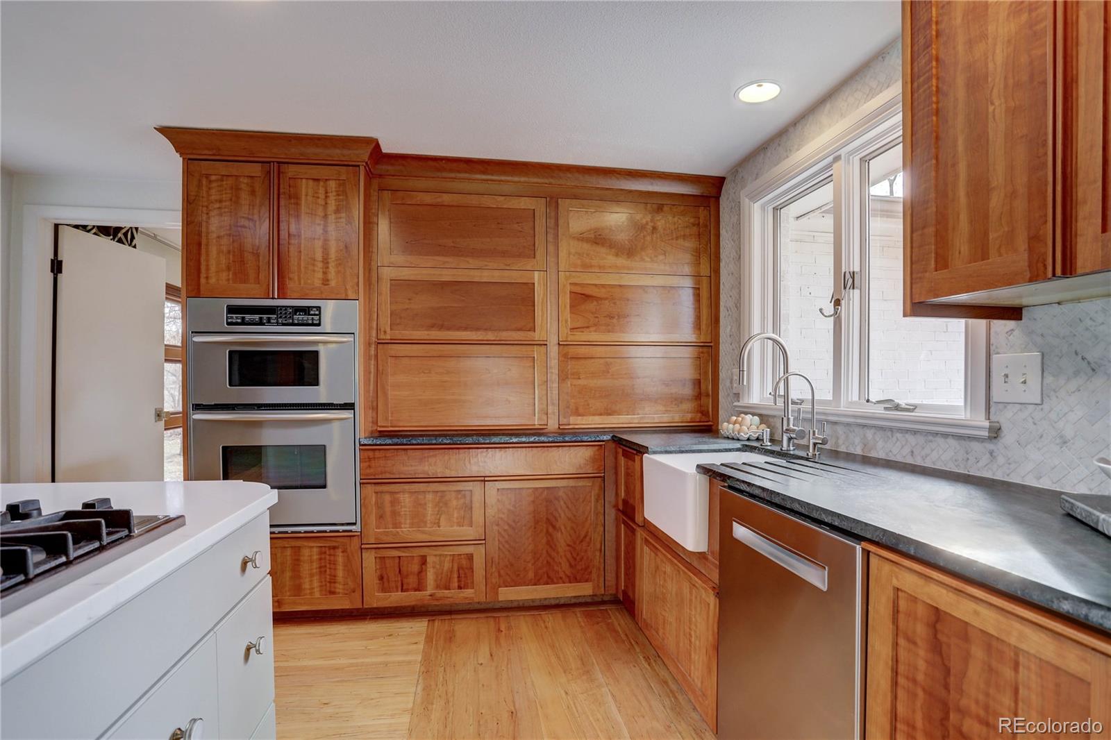 933 Cherryvale Road Boulder, CO 80303 - Photo 10 of 32 a kitchen with stainless steel appliances wooden cabinets and a stove top oven