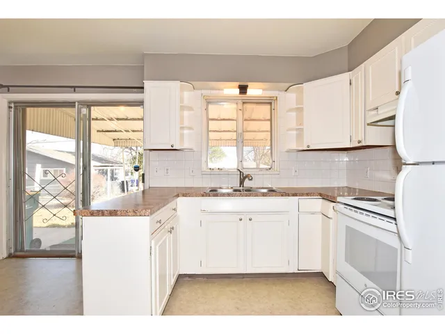 a kitchen with stainless steel appliances granite countertop a sink and cabinets with wooden floor