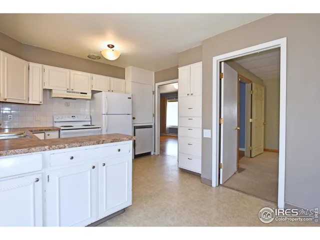 a kitchen with cabinets and a refrigerator