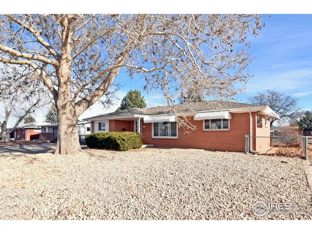 a front view of a house with a yard covered in snow