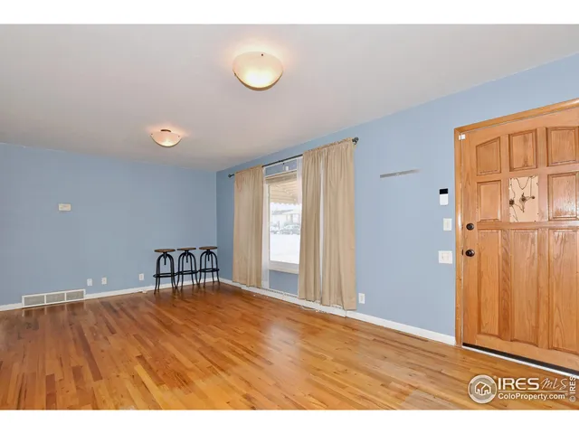 a view of a livingroom with wooden floor and a window