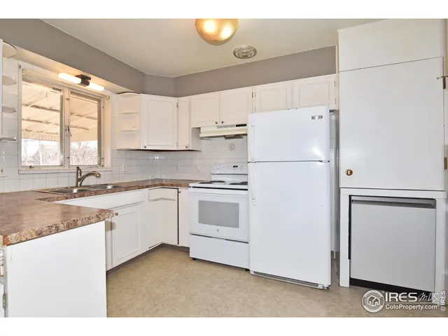 a kitchen with cabinets appliances a sink and a window