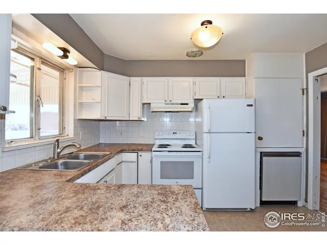 a kitchen with kitchen island white cabinets and refrigerator