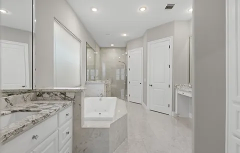 a bathroom with a granite countertop sink a toilet and shower