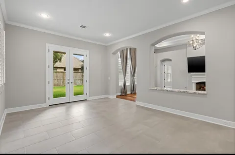 an empty room with windows and fireplace