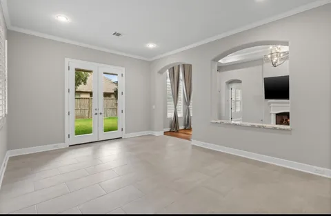an empty room with windows fireplace and flat screen tv