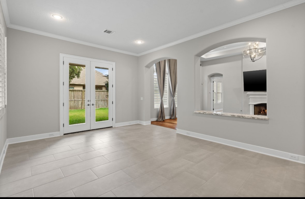 11206 Castille Lane Houston, TX 77082 - Photo 24 of 45 an empty room with windows fireplace and flat screen tv
