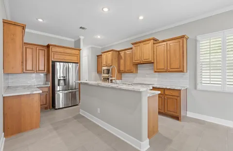 a kitchen with stainless steel appliances granite countertop a refrigerator and wooden cabinets