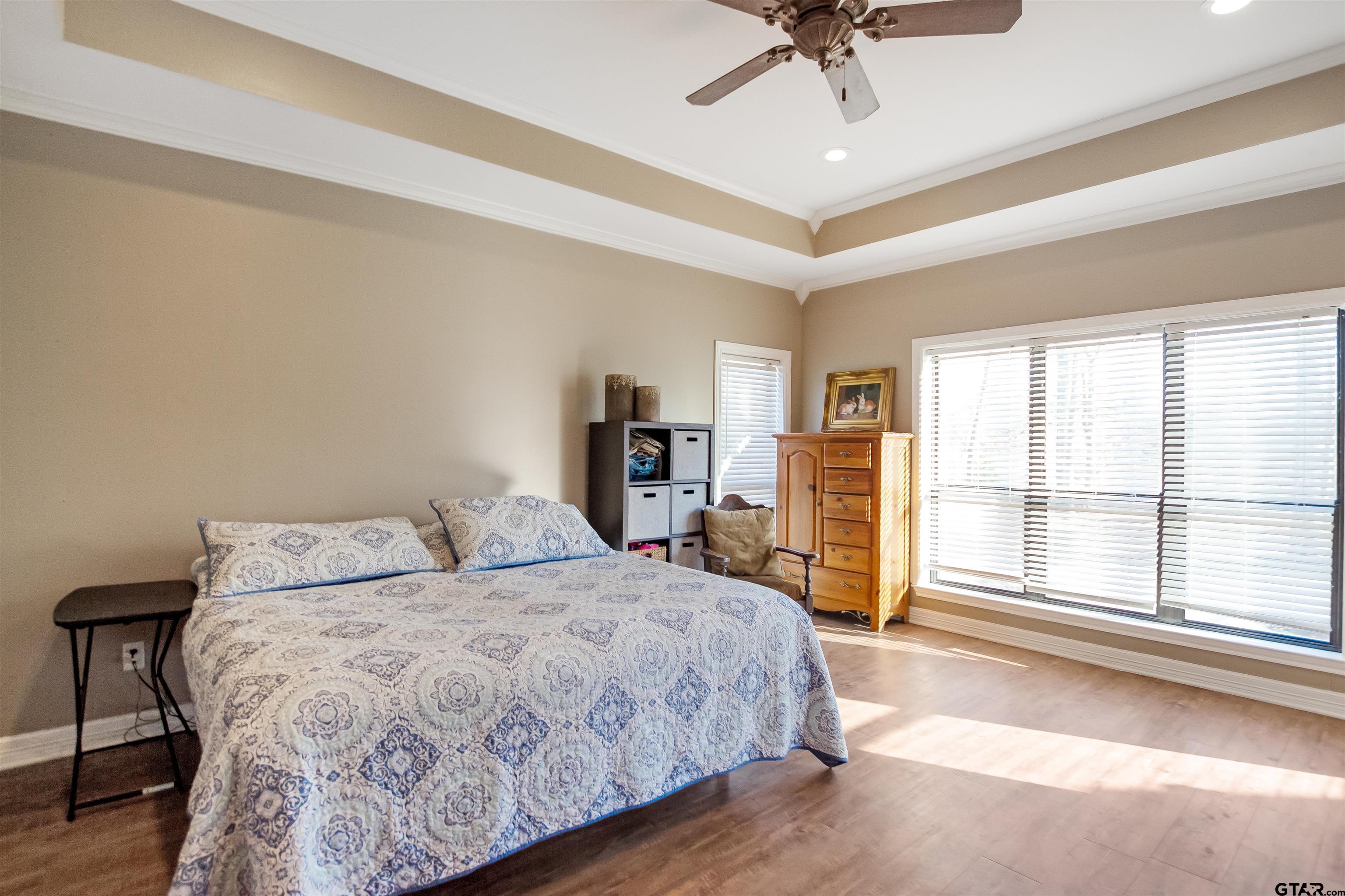 1687 West Point Road Kilgore, TX 75662 - Photo 24 of 41 a bedroom with a large bed and a chandelier