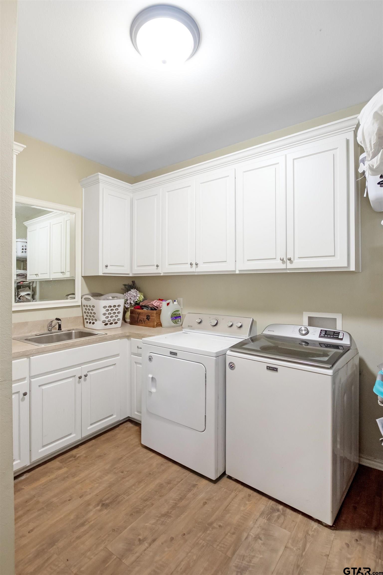 1687 West Point Road Kilgore, TX 75662 - Photo 10 of 41 a kitchen with granite countertop a sink and white cabinets
