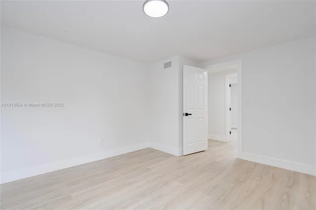 an empty room with windows and closet