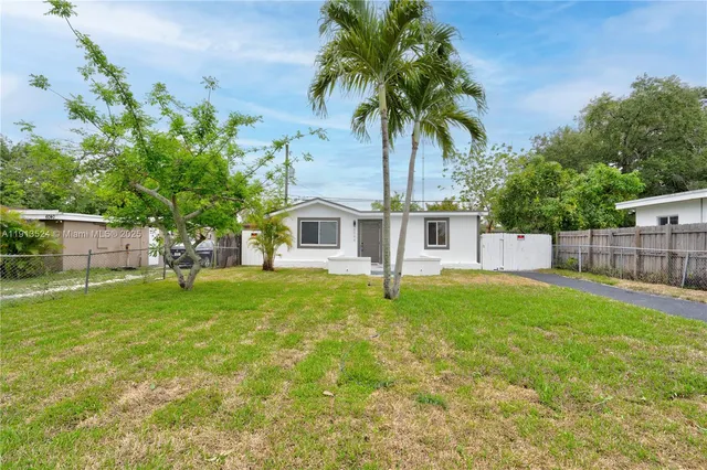 a front view of a house with yard and tree