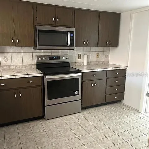 a kitchen with granite countertop a stove and a microwave