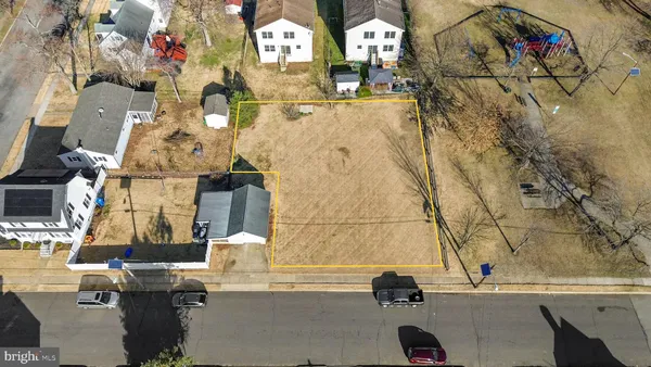 an aerial view of residential houses with outdoor space and parking