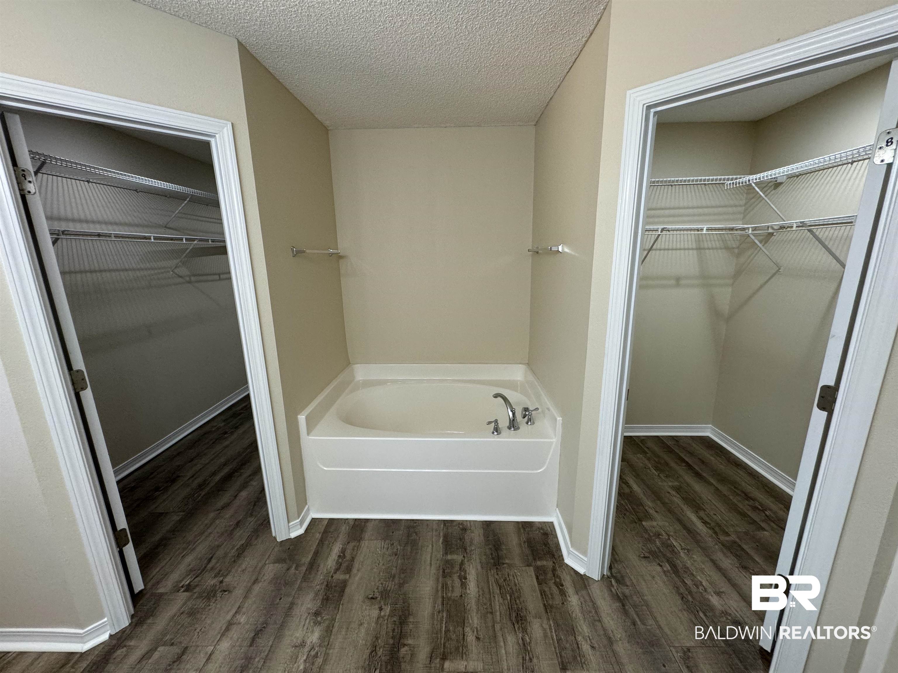32769 Arbor Ridge Circle Lillian, AL 36549 - Photo 14 of 36 Bathroom featuring wood-type flooring, a textured ceiling, and a bathtub