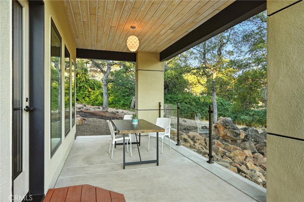 17234 Brookfield Road Hidden Valley Lake, CA 95467 - Photo 32 of 35 a view of a patio with table and chairs and floor to ceiling window