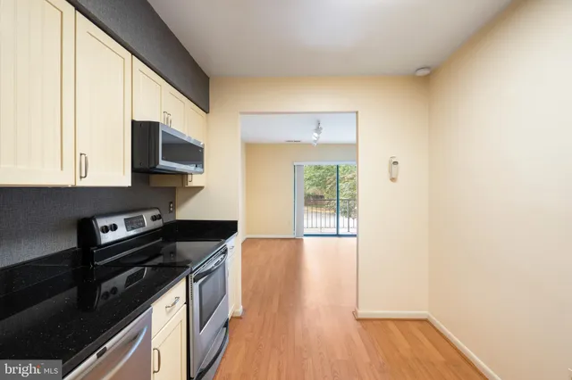 a kitchen with stainless steel appliances a stove a microwave and cabinets