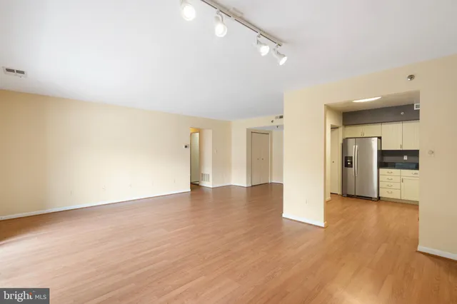 a view of an empty room with wooden floor