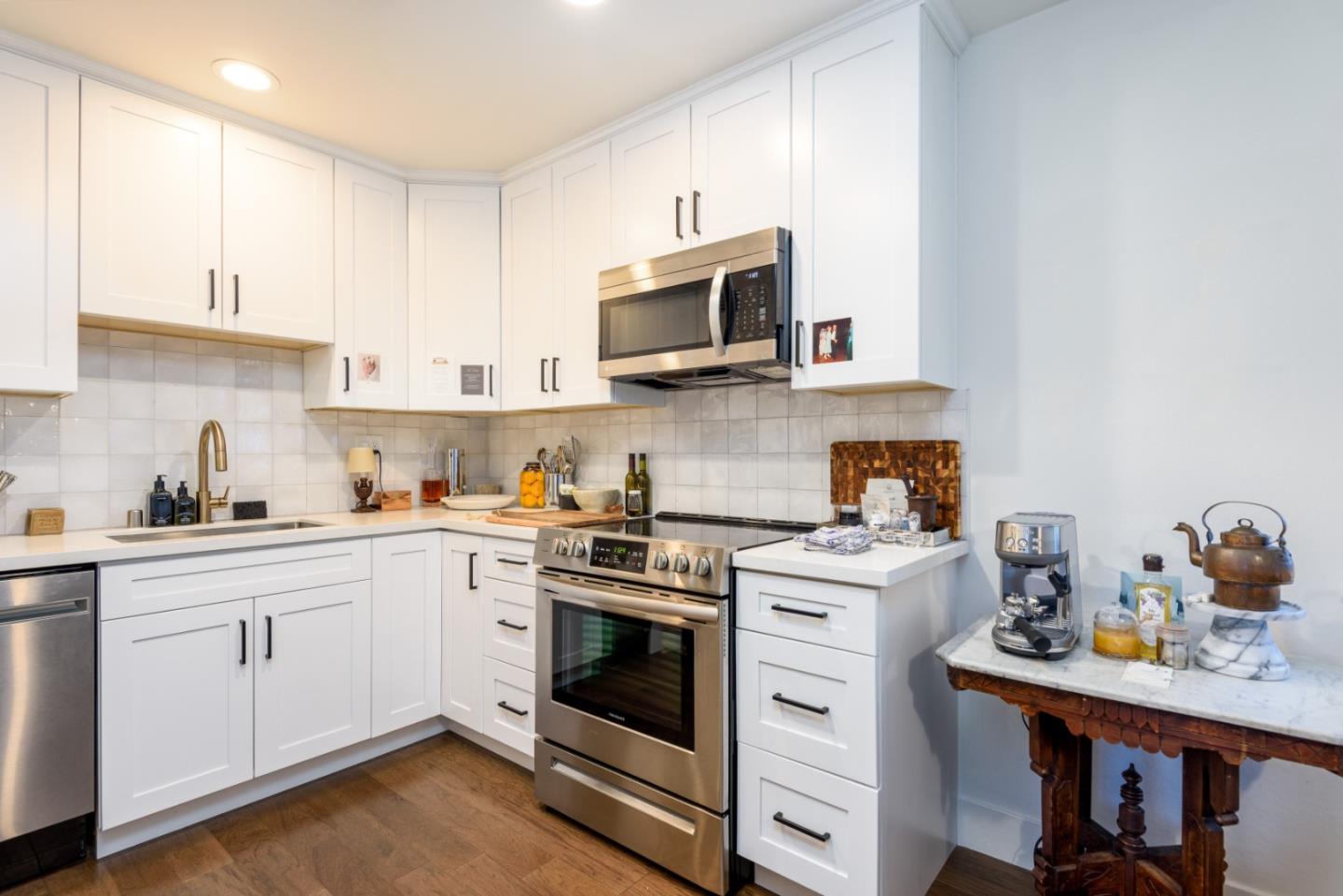 1437 Floribunda Avenue Burlingame, CA 94010 - Photo 11 of 35 a kitchen with stainless steel appliances granite countertop a sink a stove and microwave with wooden floor