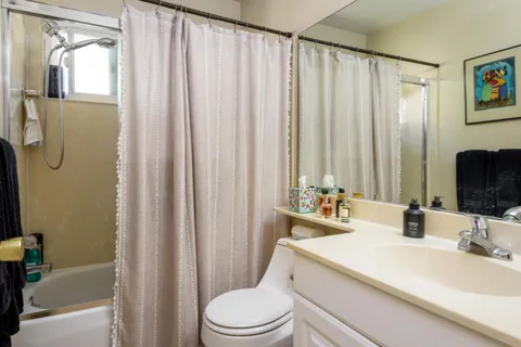 a bathroom with a sink a toilet and shower curtain