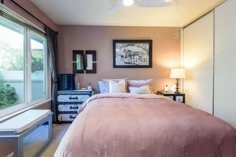 a bedroom with a bed and a large window with outer view