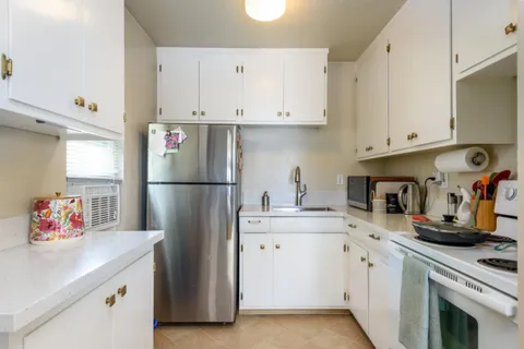 a kitchen with stainless steel appliances a refrigerator sink and cabinets