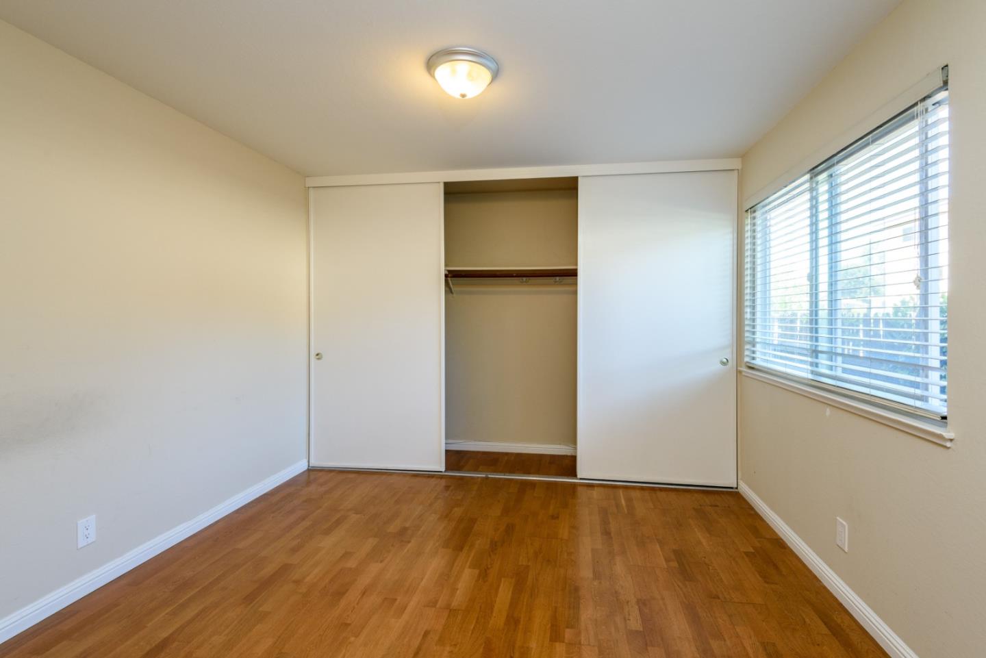 1437 Floribunda Avenue Burlingame, CA 94010 - Photo 20 of 35 a view of an empty room with wooden floor and a window