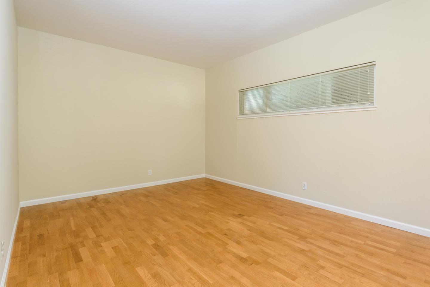 1437 Floribunda Avenue Burlingame, CA 94010 - Photo 25 of 35 an empty room with wooden floor and mirror