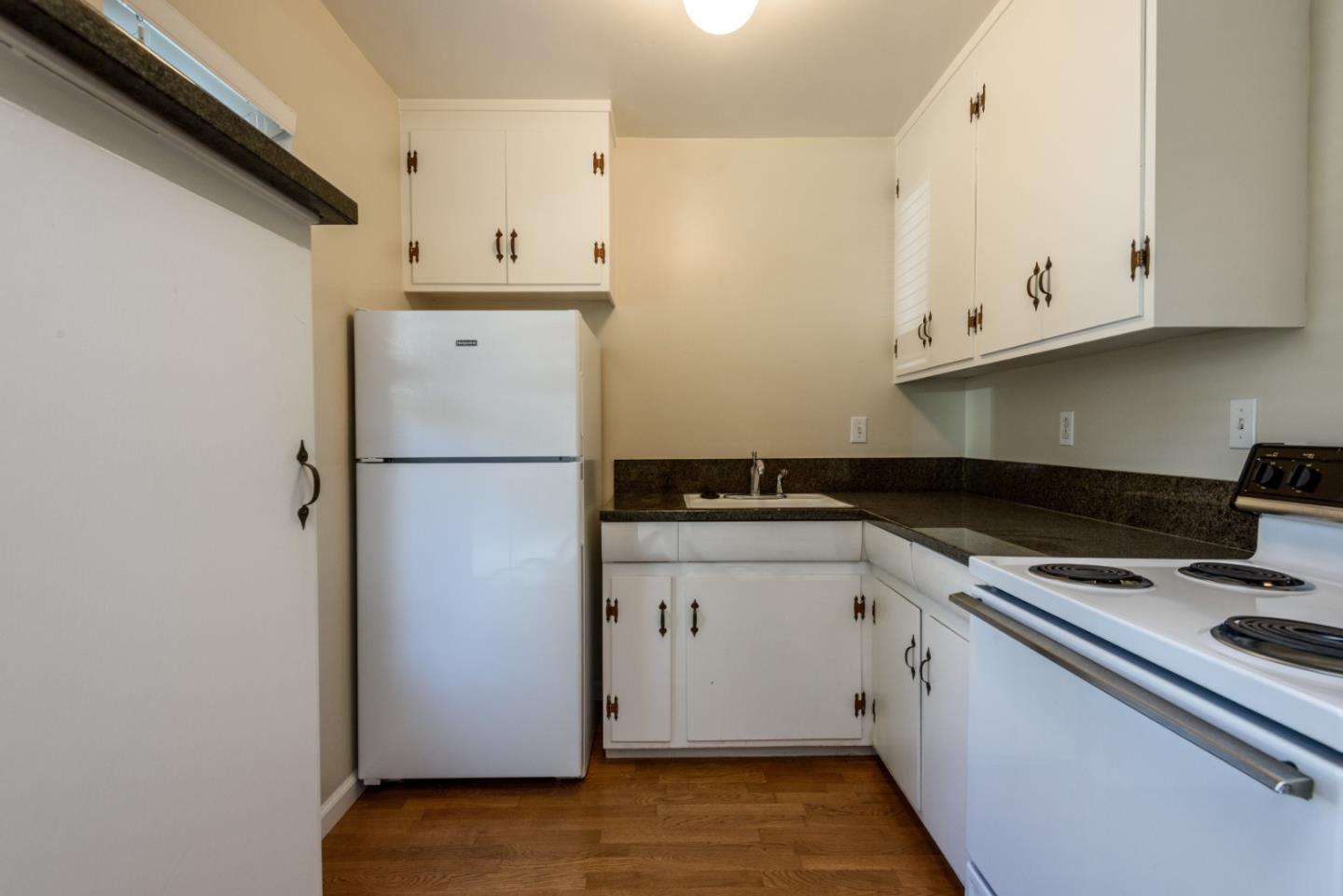 1437 Floribunda Avenue Burlingame, CA 94010 - Photo 27 of 35 a kitchen with stainless steel appliances a refrigerator a stove and white cabinets