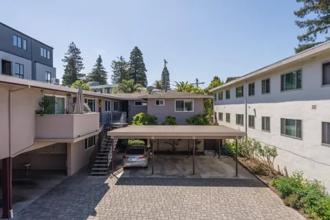 a view of a house with wooden deck and furniture