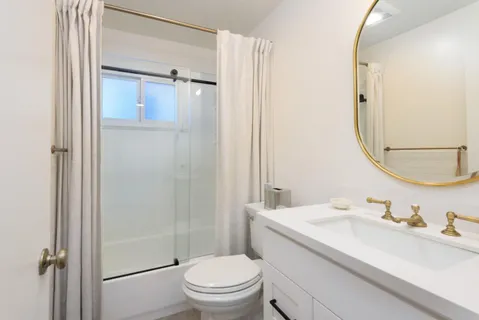 a bathroom with a granite countertop sink toilet and shower