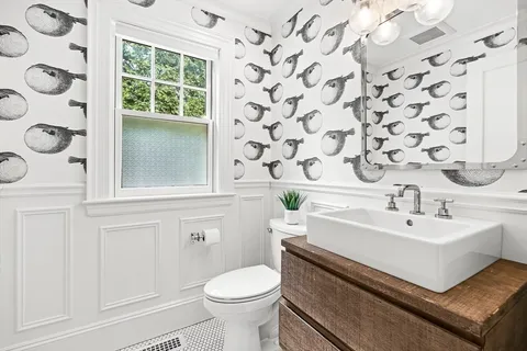 a bathroom with a sink toilet and mirror