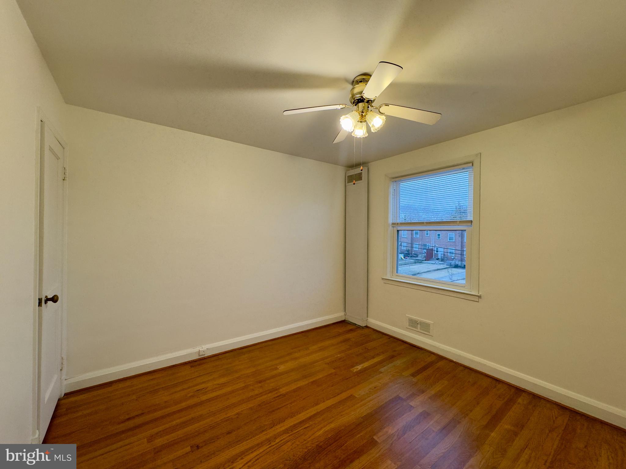 712 Bethnal Road Baltimore, MD 21229 - Photo 17 of 20 a view of an empty room with a window and wooden floor
