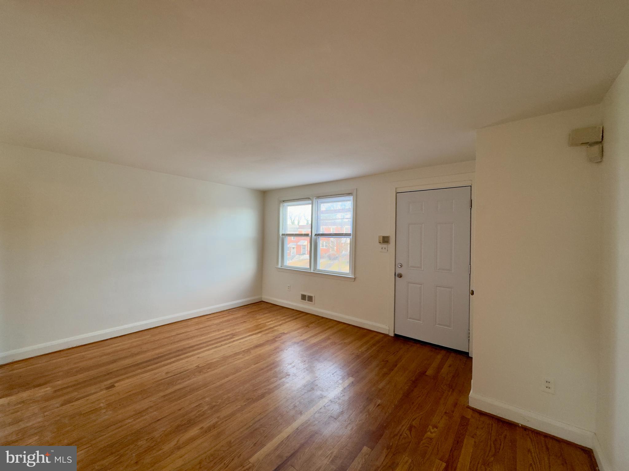 712 Bethnal Road Baltimore, MD 21229 - Photo 18 of 20 an empty room with wooden floor and windows