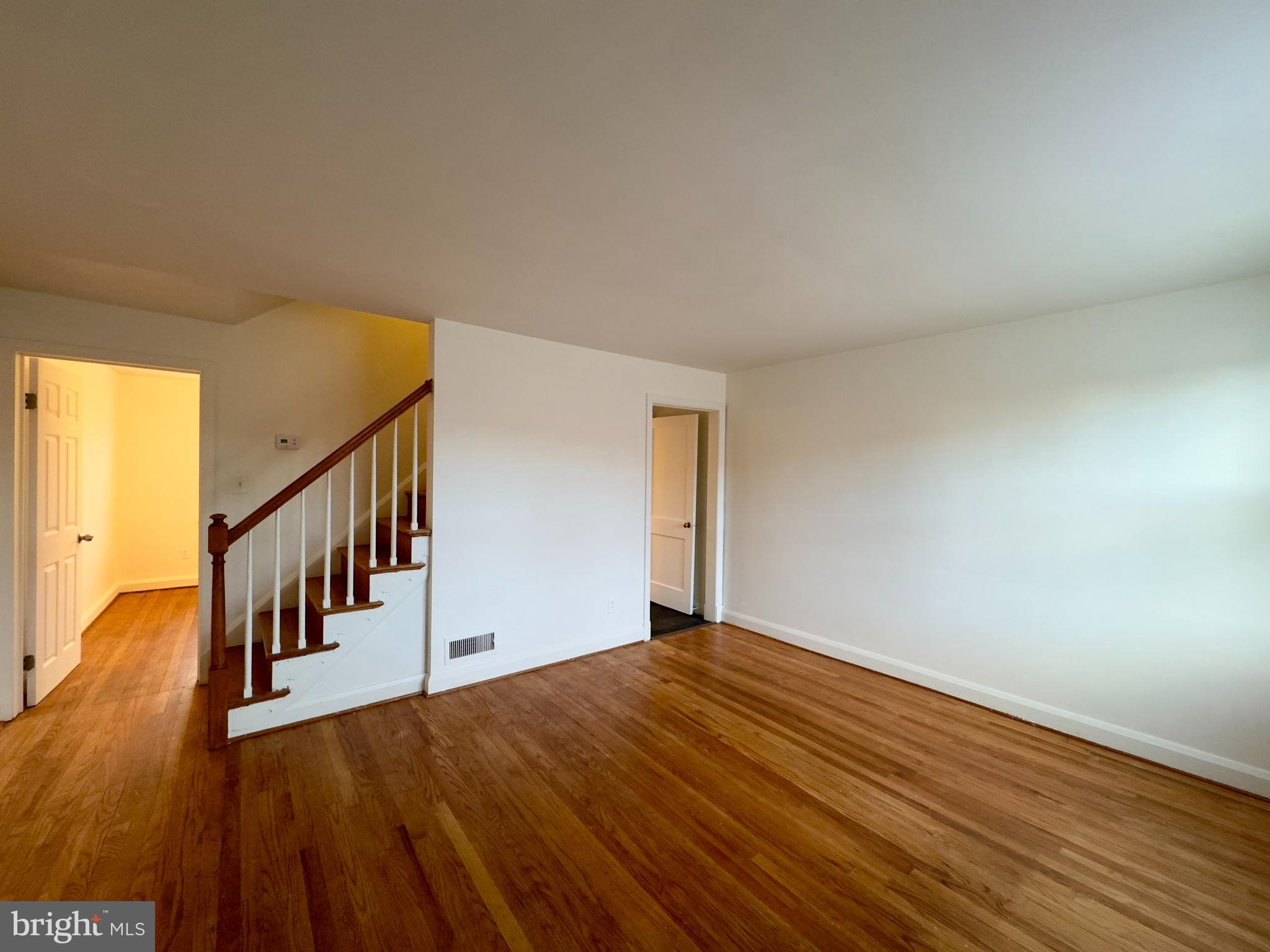 712 Bethnal Road Baltimore, MD 21229 - Photo 19 of 20 a view of an empty room with wooden floor and stairs