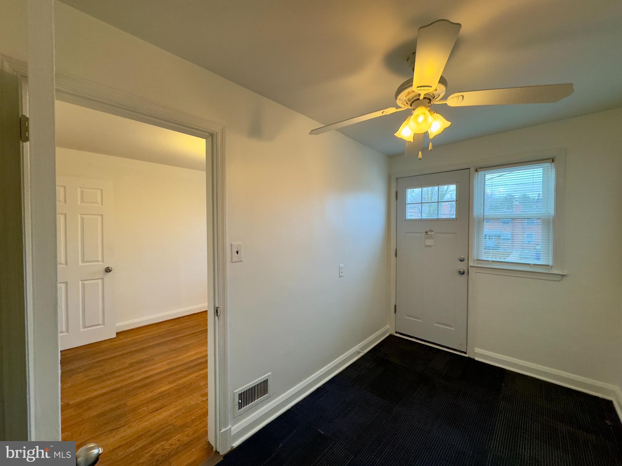 712 Bethnal Road Baltimore, MD 21229 - Photo 2 of 20 a view of an empty room with window and wooden floor