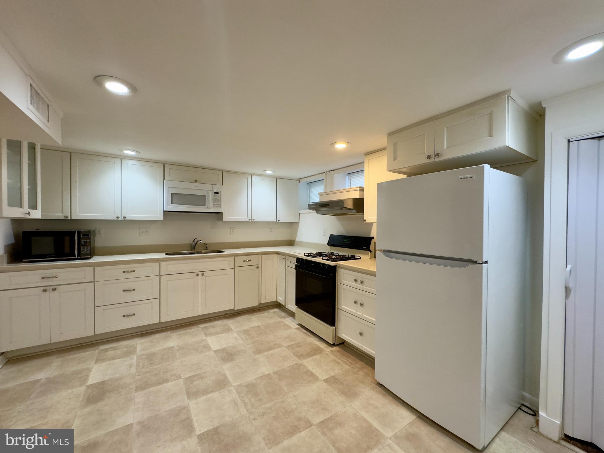 712 Bethnal Road Baltimore, MD 21229 - Photo 6 of 20 a kitchen with a refrigerator a sink and cabinets