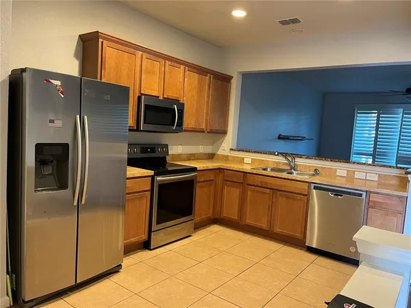 a kitchen with stainless steel appliances granite countertop a refrigerator and a sink