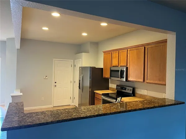 a kitchen with granite countertop sink cabinets and stainless steel appliances