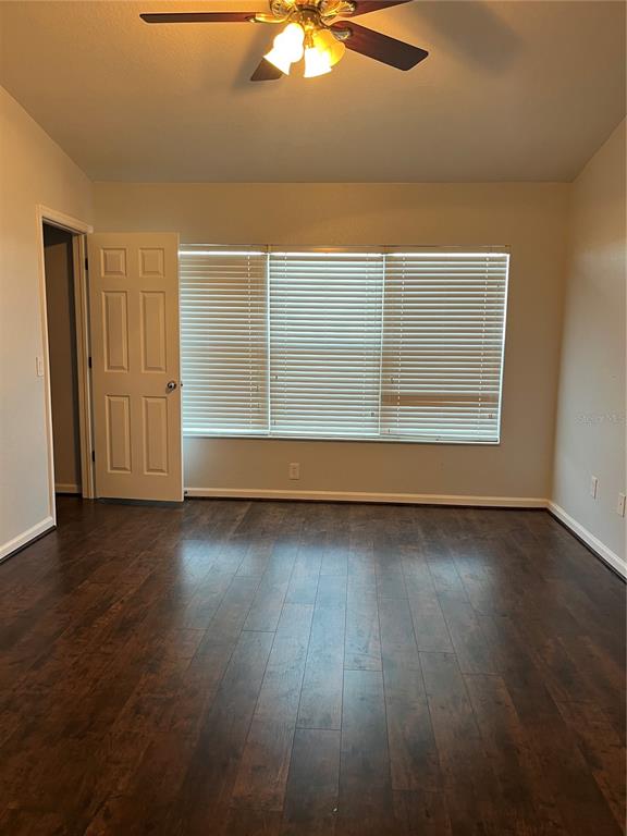 4971 Southwest 45th Street Ocala, FL 34474 - Photo 10 of 14 an empty room with wooden floor fan and windows